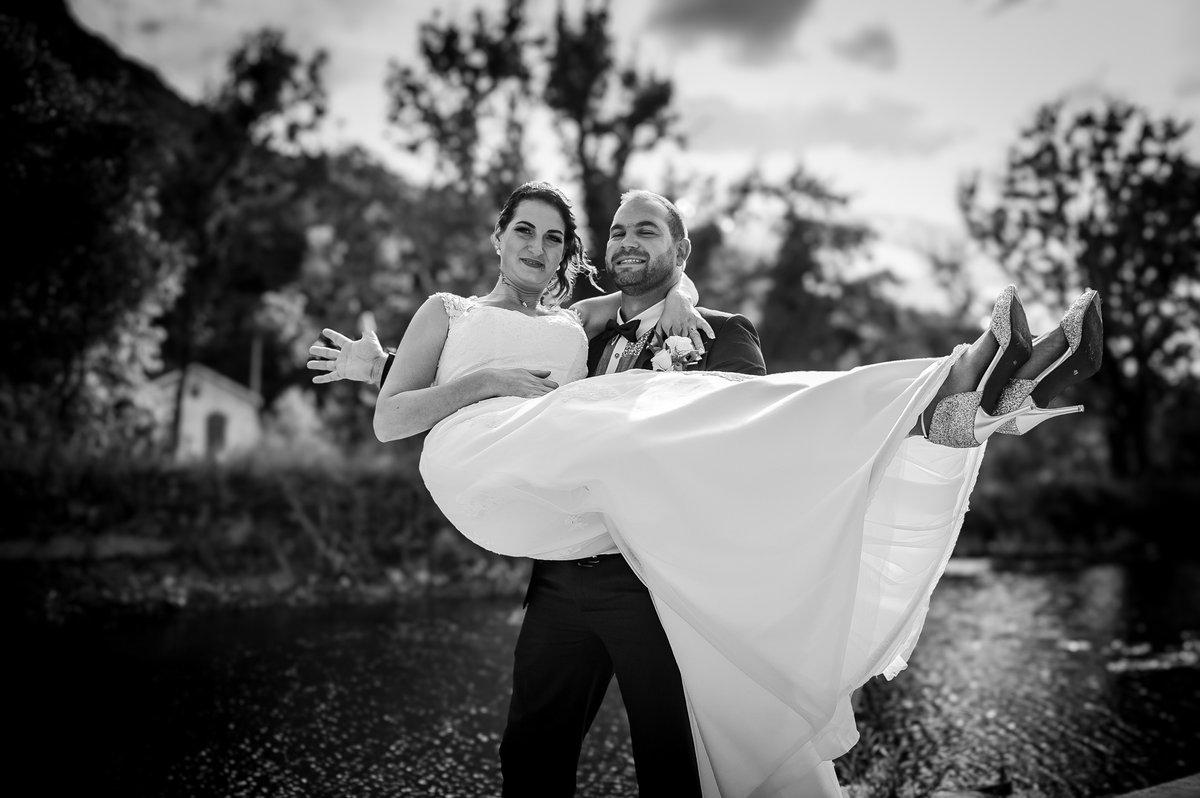 Marié portant la mariée devant un paysage