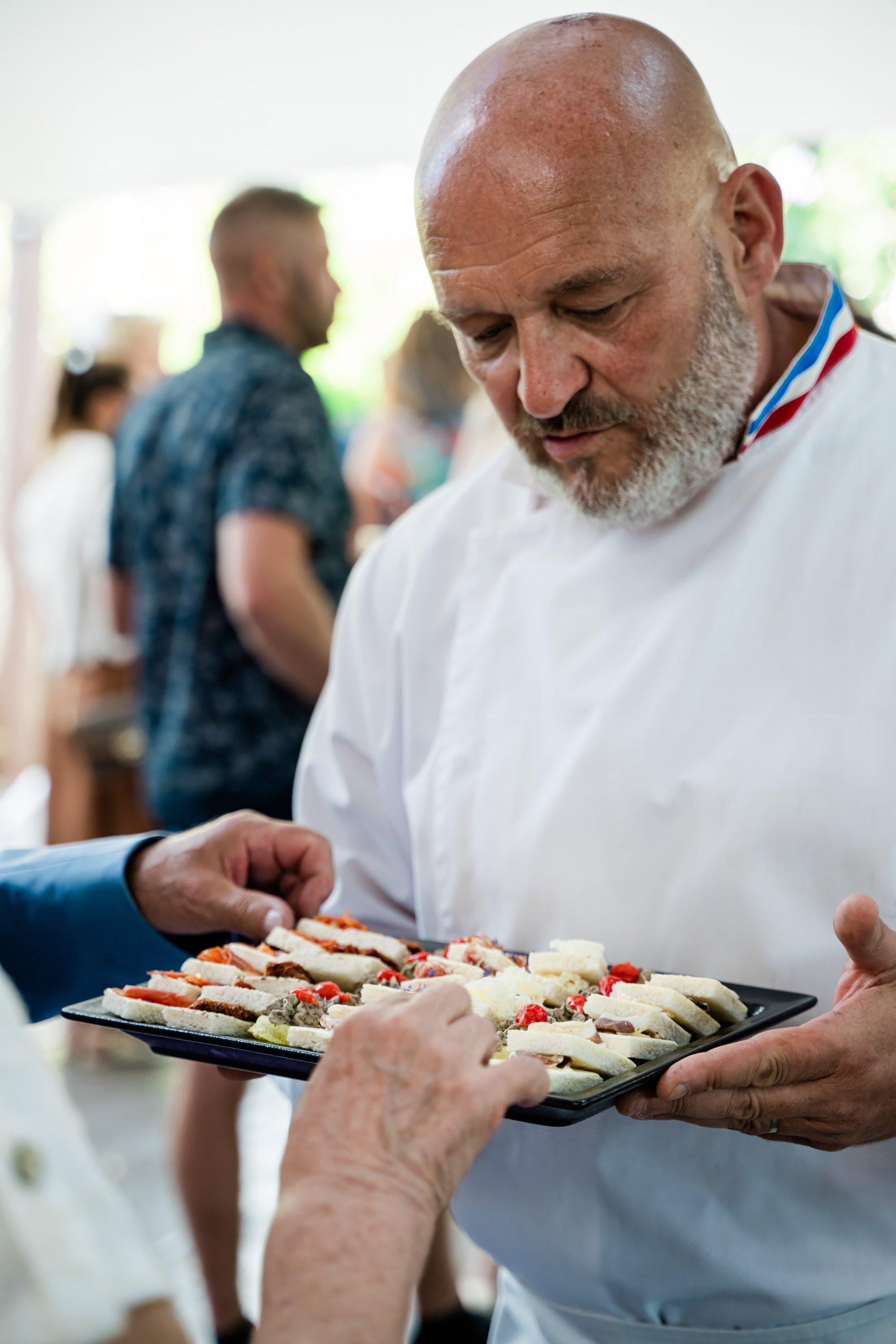 Chef cuisinier présentant un plateau de canapés aux invités