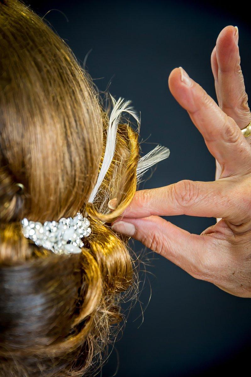 Insertion d'une plume dans la coiffure de mariée