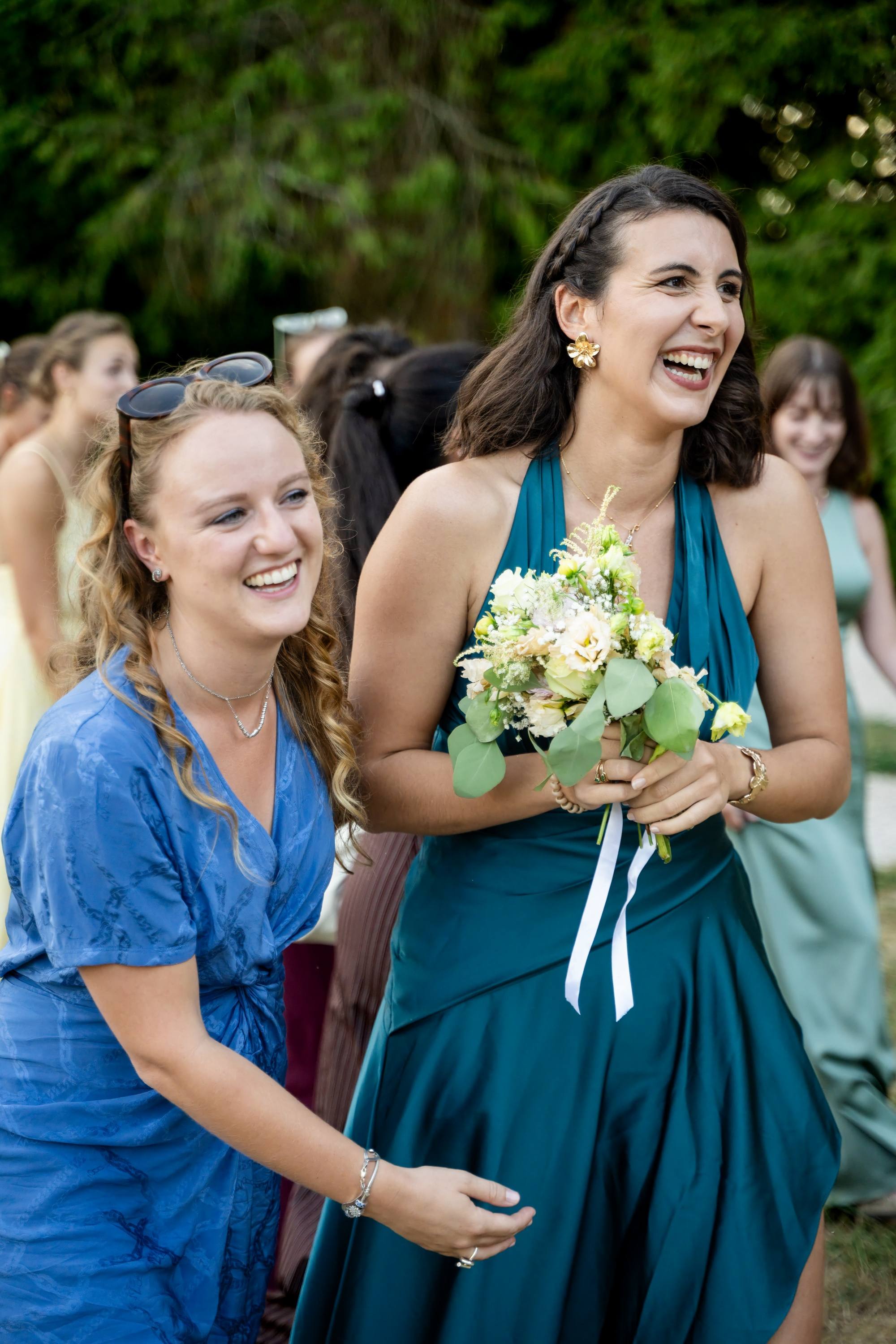 Invitée émue tenant le bouquet de la mariée après le lancer