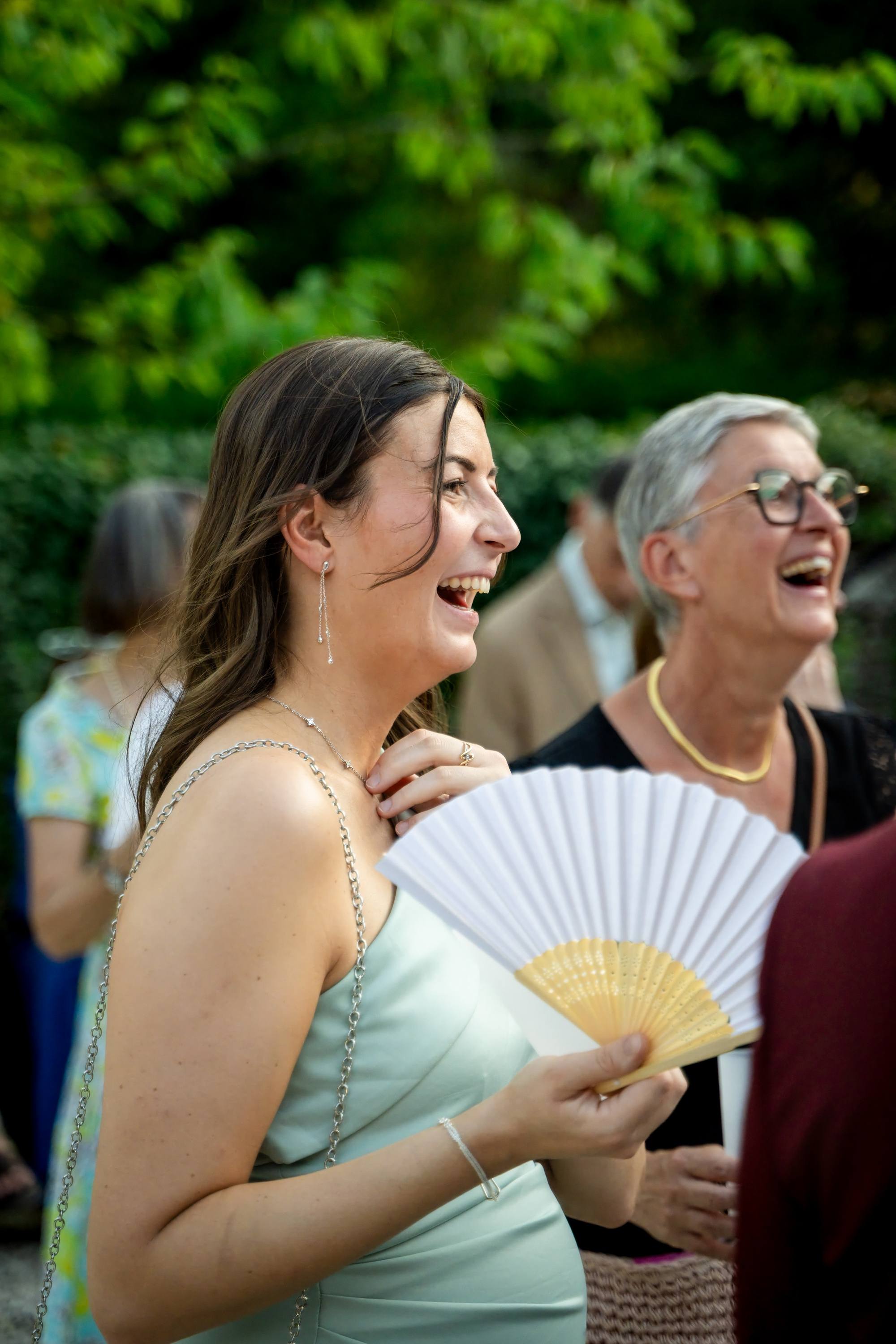 Invitée avec un éventail, éclats de rire pendant le cocktail