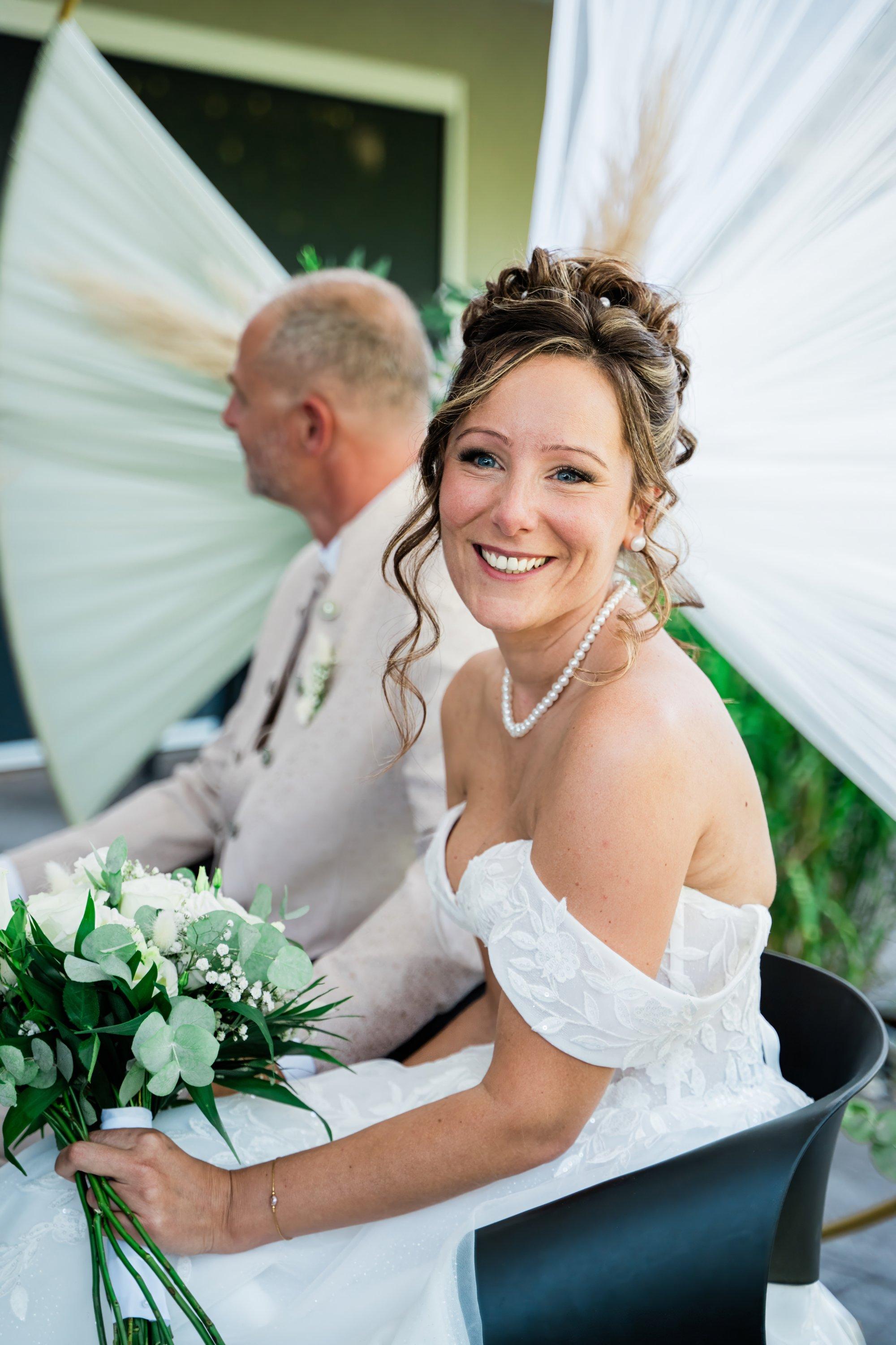 Mariée souriante assise pendant la cérémonie laïque