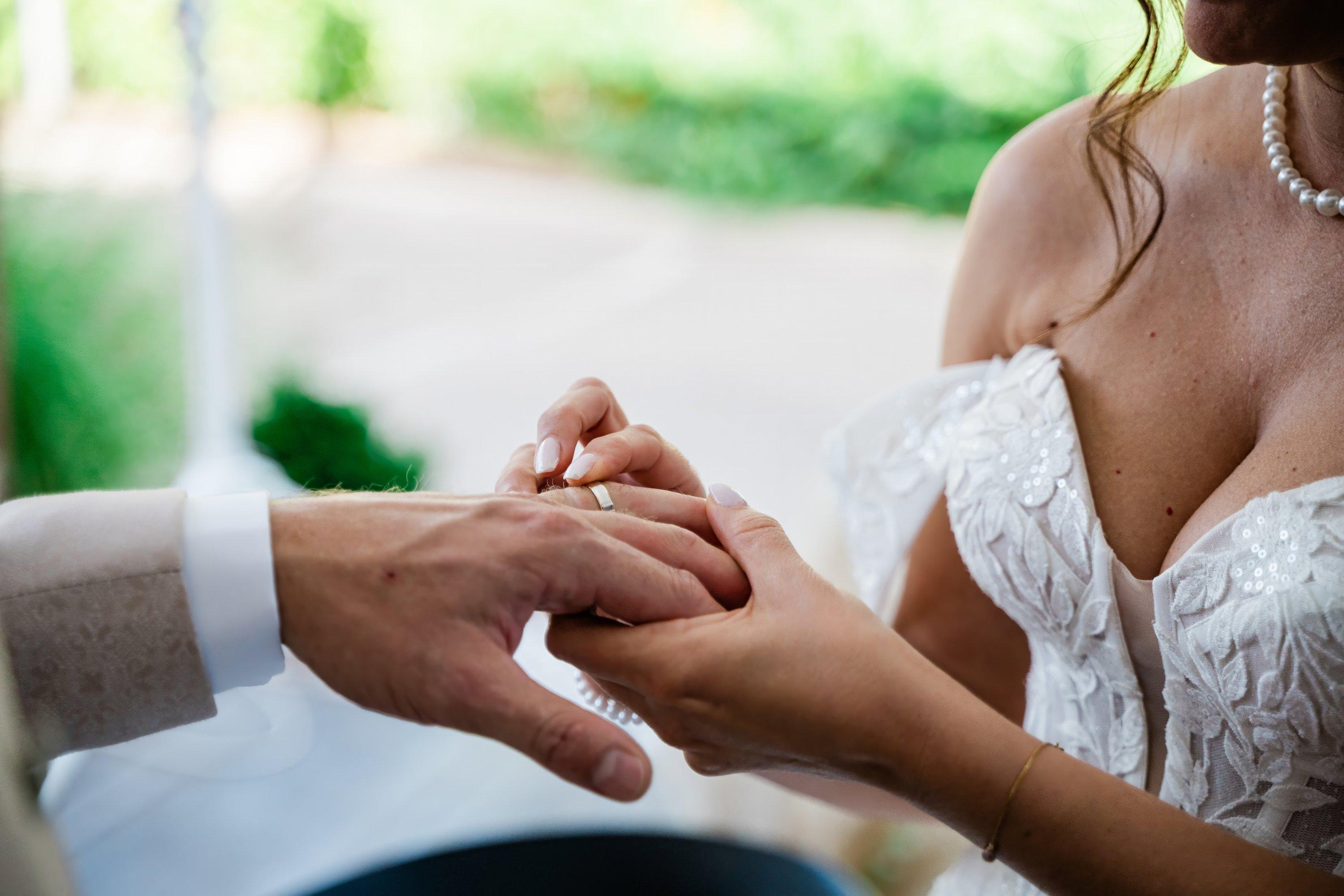Le marié passe l'alliance au doigt de la mariée