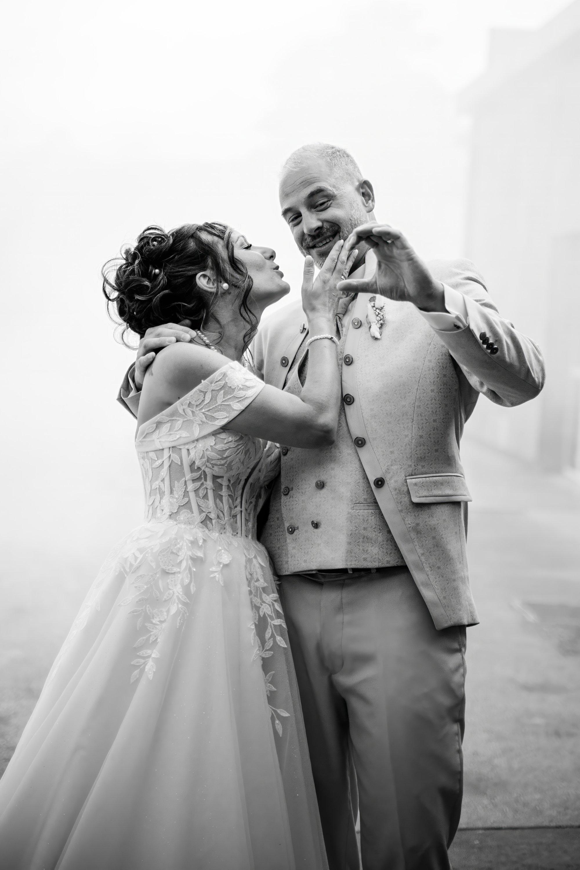 Les mariés forment un cœur avec leurs mains, photo noir et blanc