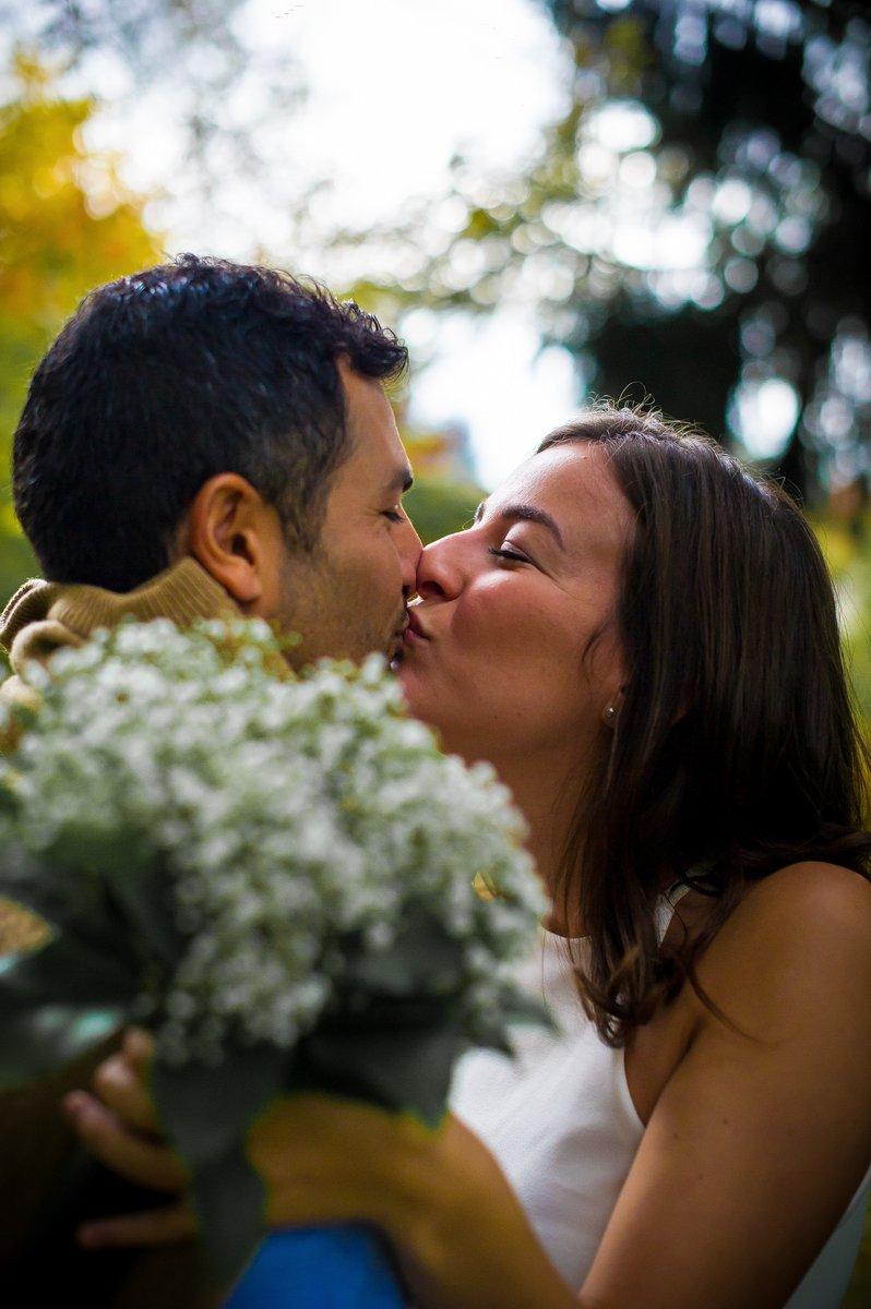 Les futurs mariés s'embrassent avec un bouquet de fleurs