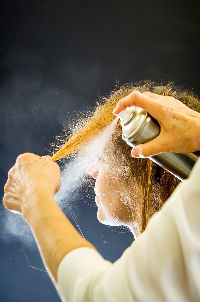 Coiffeuse appliquant de la laque sur les cheveux
