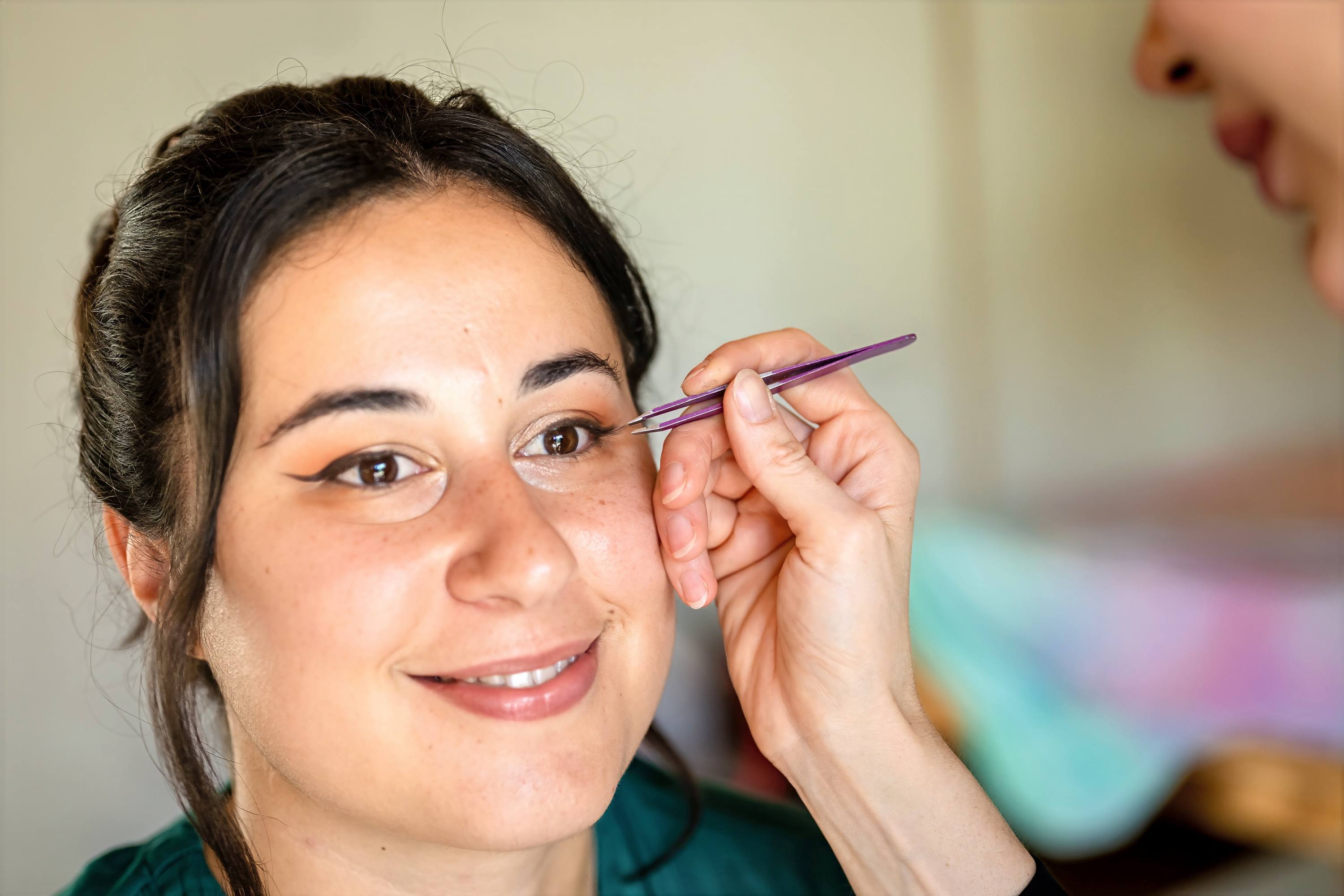 Mise en beauté de la mariée par une maquilleuse avant la cérémonie