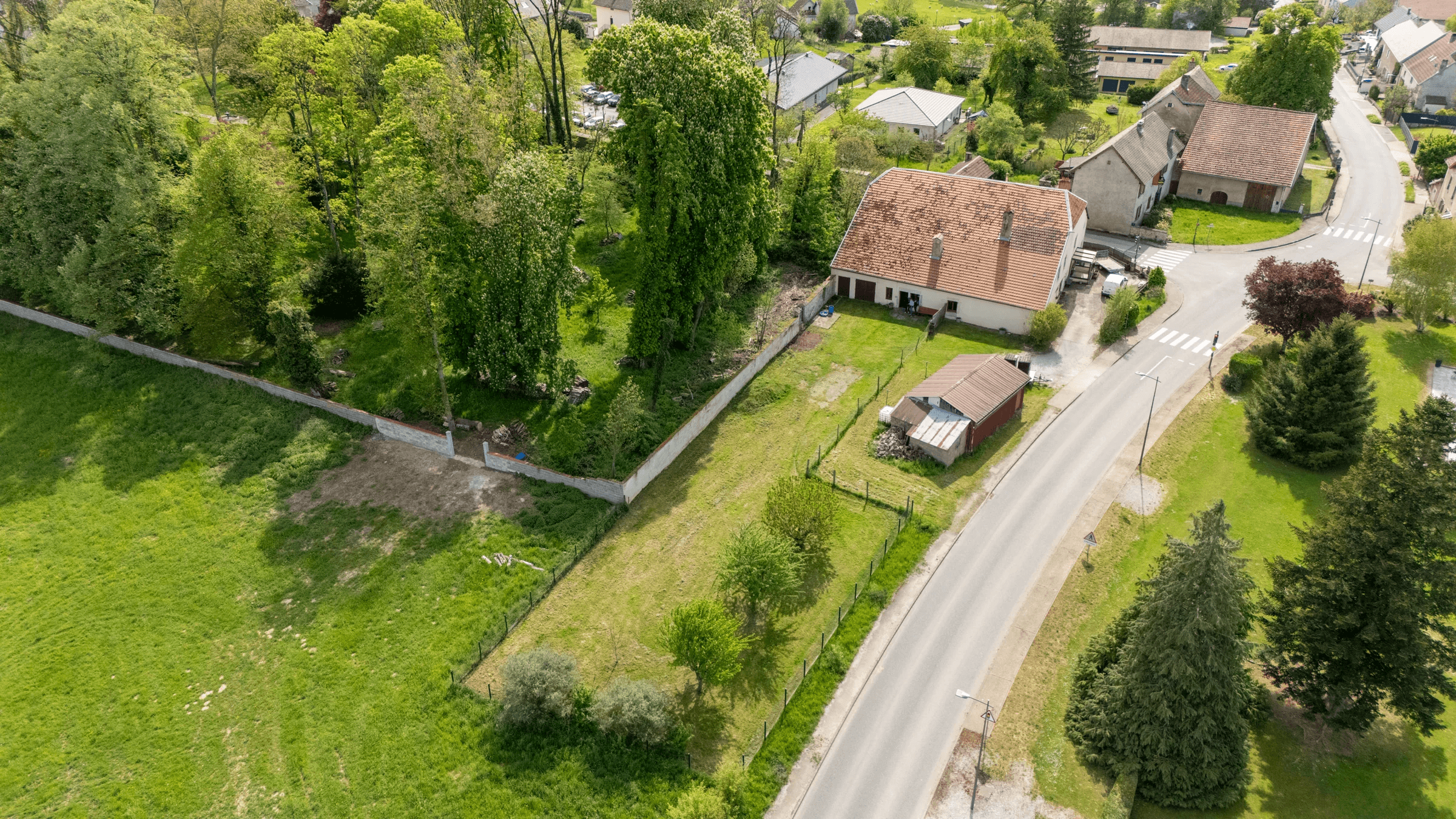 Maison et grand terrain dans un village vus par drone