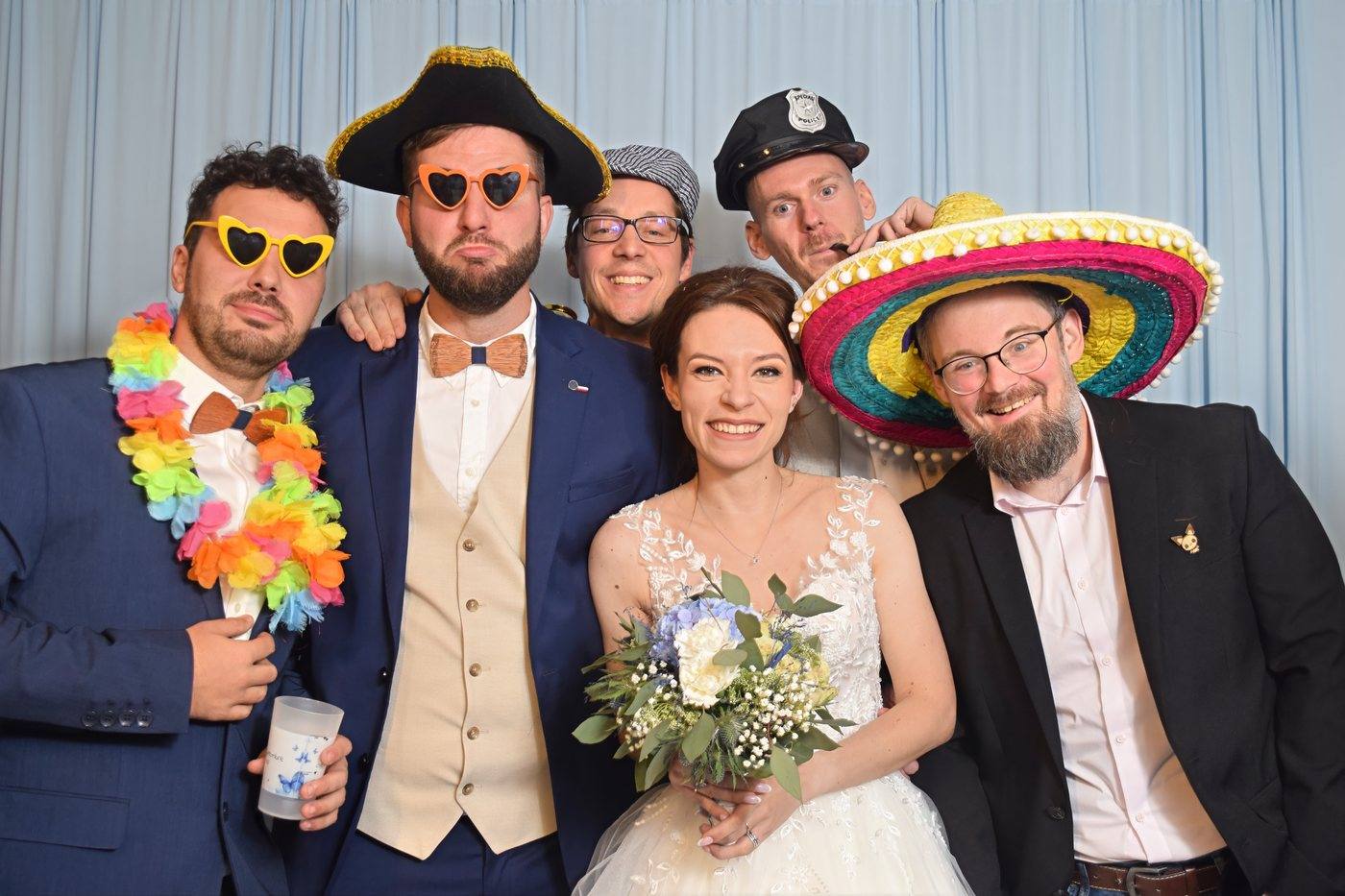 Les mariés et leurs témoins déguisés avec sombrero et lunettes en cœur au photobooth