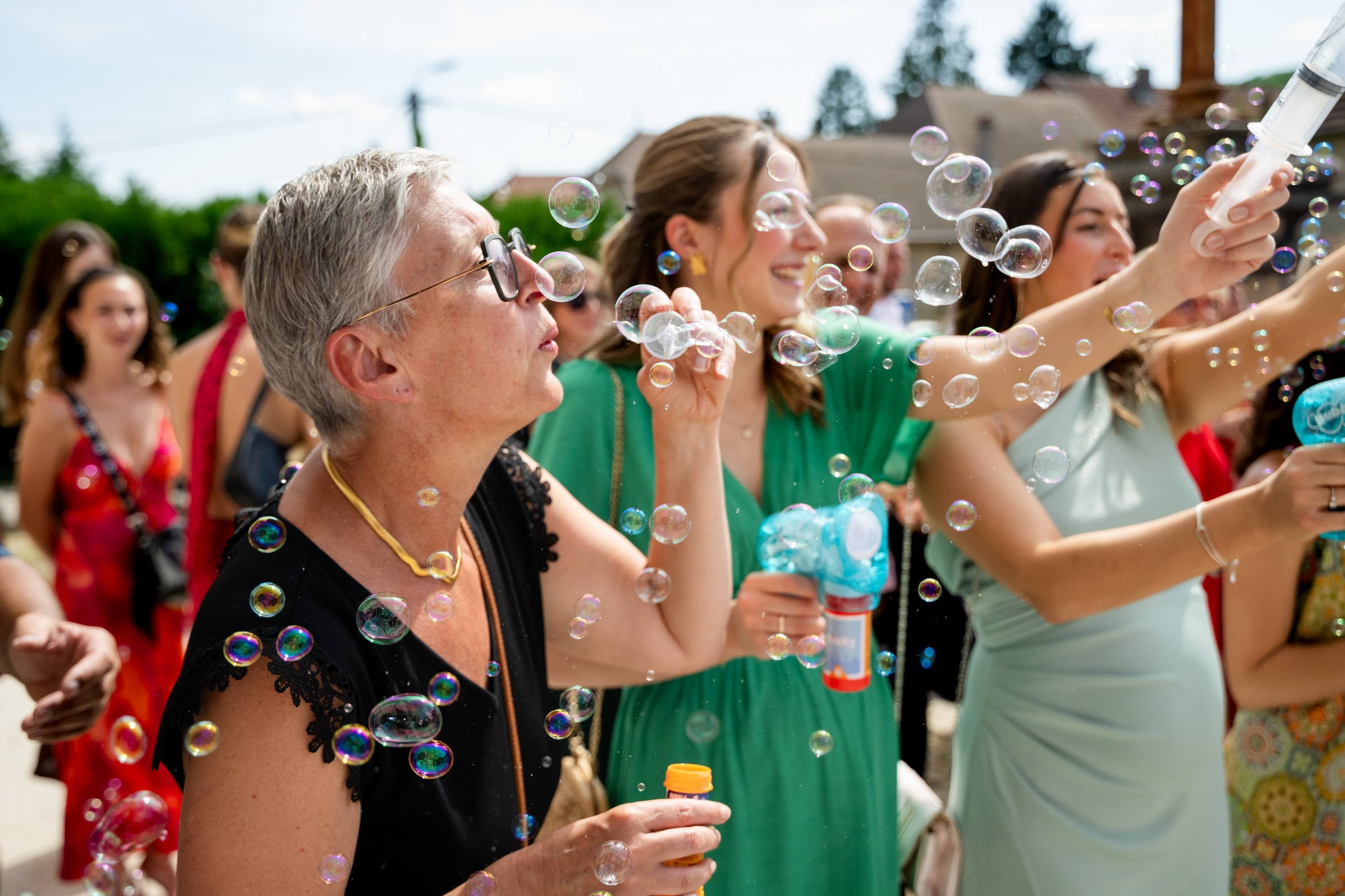 Sortie d'église sous les bulles de savon lancées par les invités, mariage vers Thise