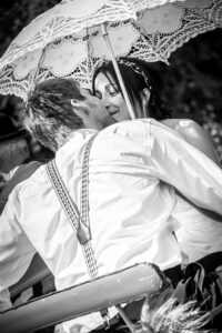 Les mariés s'embrassent sous une ombrelle Mariés s'embrassant sous une ombrelle lors de leur mariage