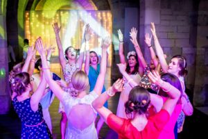 Invités les bras en l'air lors de la soirée de mariage aux couleurs vives Invités avec les bras levés lors de la soirée de mariage aux couleurs vives