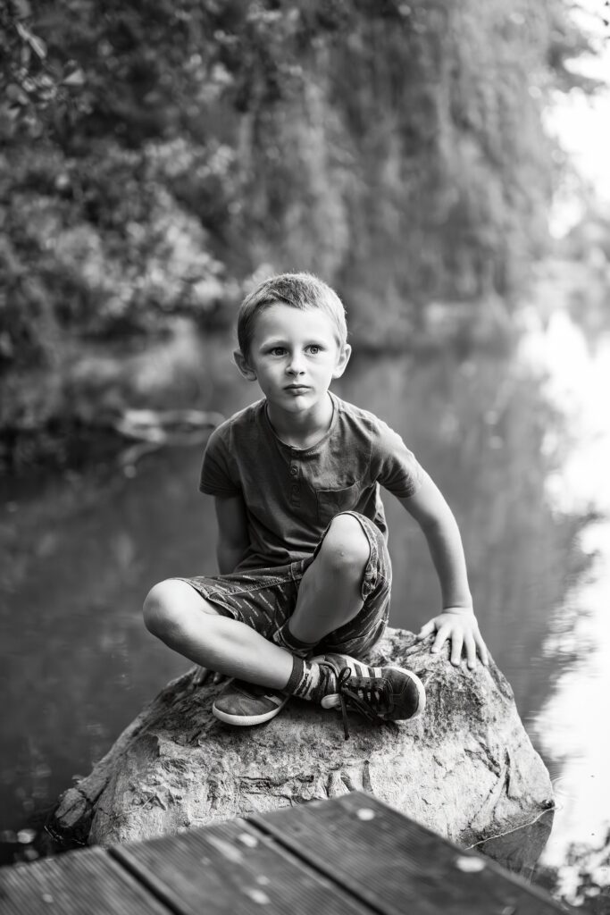 enfant-assis-sur-un-rocher-au-bord-d-un-rivière