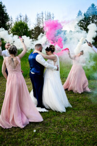 Les mariés dansant tandis que les invités font des fumigènes blancs et roses Mariés dansant avec des fumigènes blancs et roses allumés par les invités