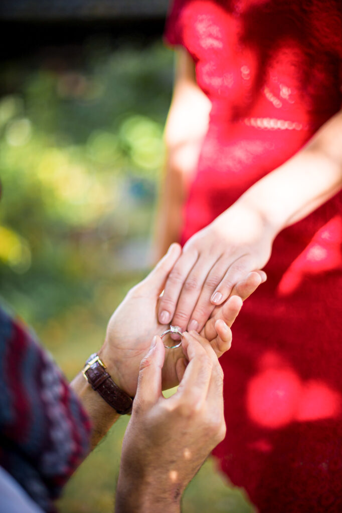 Love session : le futur marié passe la bague au doigt de sa fiancée Futur marié passant la bague au doigt de sa fiancée