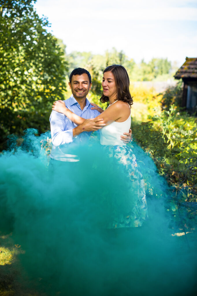 Love session : les futurs mariés dansent dans une fumée verte dans le jardin Futurs mariés dansant dans une fumée verte dans le jardin