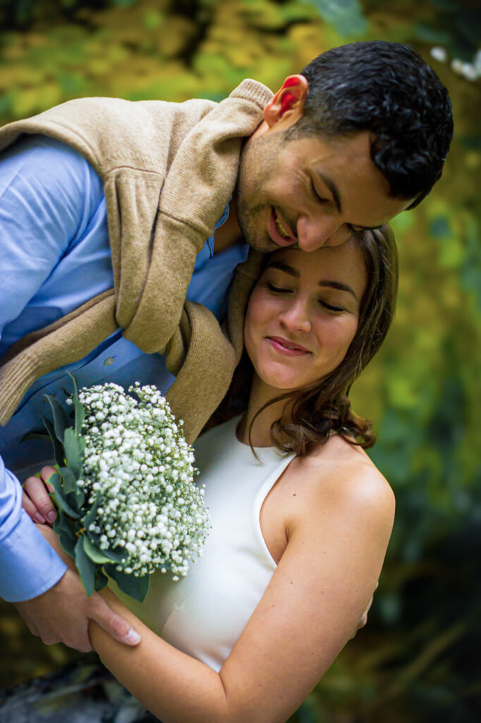 Love session : les futurs mariés enlacés avec un bouquet de fleurs Futurs mariés enlacés avec un bouquet de fleurs