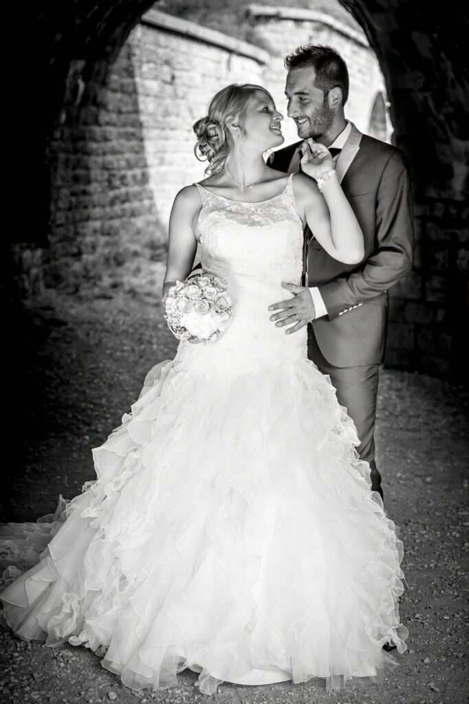 Trash the dress : les mariés s'enlacent sous une arche de pierre Mariés s'enlaçant sous une arche de pierre