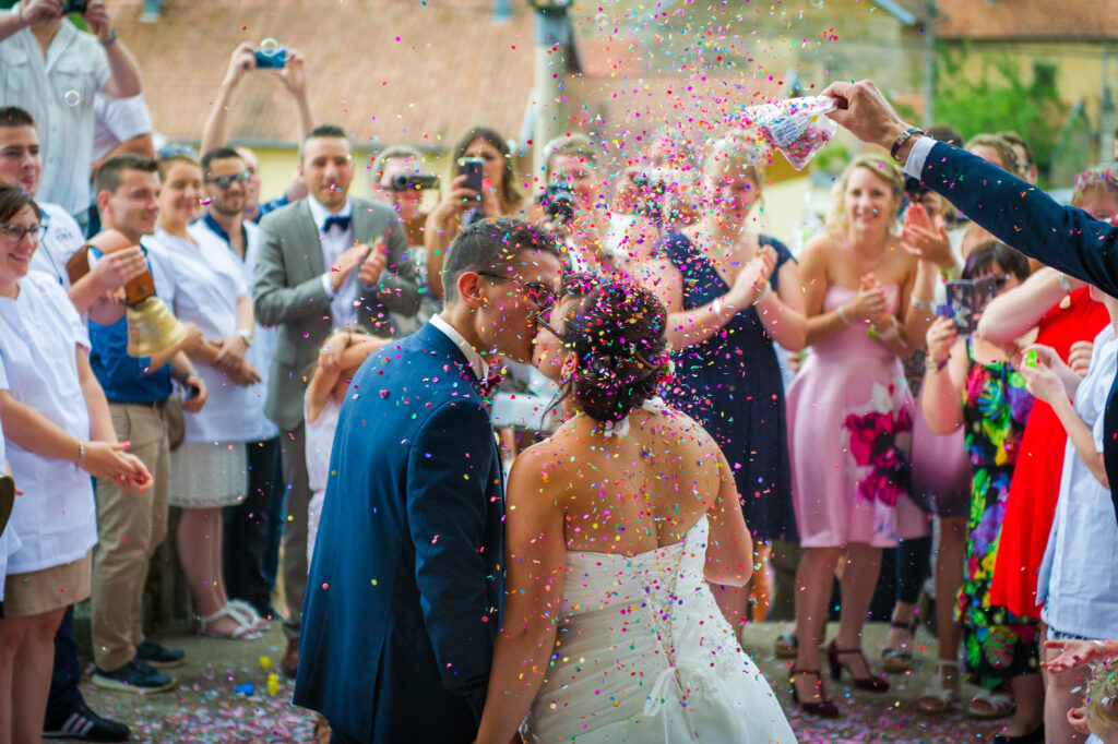 Les mariés s'embrassant sous une pluie de confettis Mariés s'embrassant avec des confettis tombant autour d'eux
