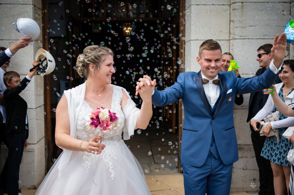 Les mariés sortant de l'église main dans la main Mariés se tenant par la main en sortant de l'église