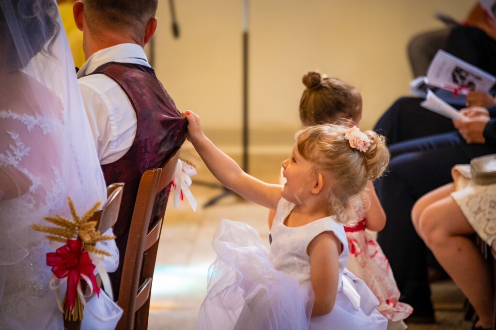 Un enfant touchant le dos des mariés assis à l'église Enfant touchant le dos des mariés assis à l'église